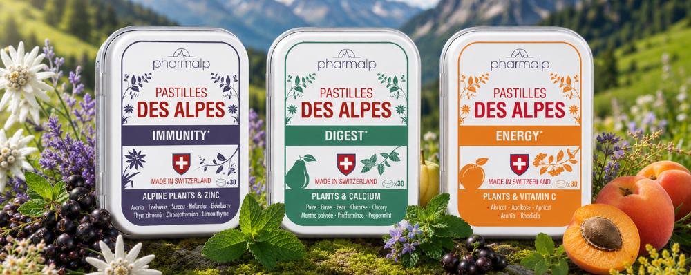 Les trois boîtes de Pastilles des Alpes — Immunity, Digest et Energy — posées sur la mousse, edelweiss et montagnes en arrière-plan